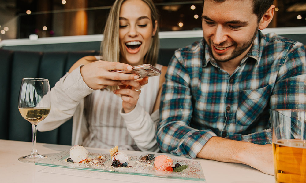 A couple taking a photo of their food at Table Rock House Restaurant